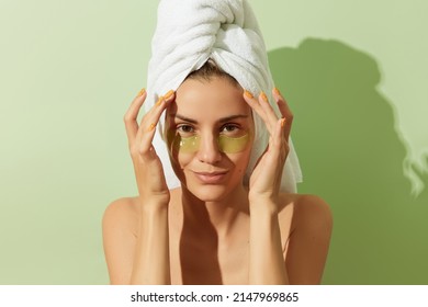 Woman in sunlight with eye patches on pastel green background. Morning skincare routine - Powered by Shutterstock