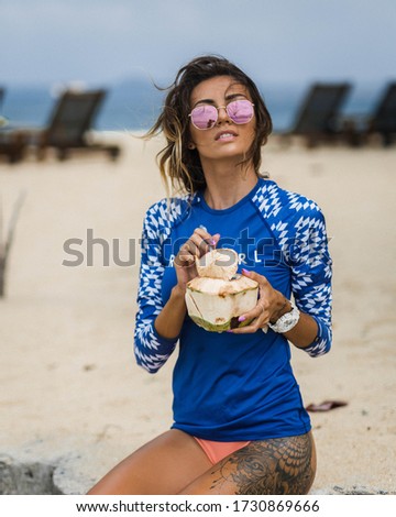Woman in sun-shirt.  Sun protection. Caucasian fit tanned woman on beach in sun shirt posing to camera.