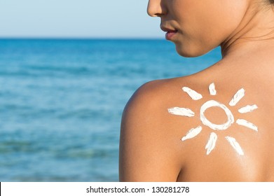 Woman With Suntan Lotion At The Beach In Form Of The Sun