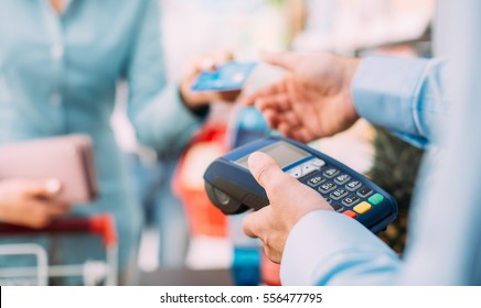 Woman At The Supermarket Checkout, She Is Paying Using A Credit Card, Shopping And Retail Concept