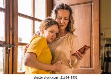 Woman Support Her Teen Daughter And Looking At Her Phone