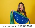 Woman supporter of Brazil, football championship, holding flag screaming goal and cheering, partying, celebrating.