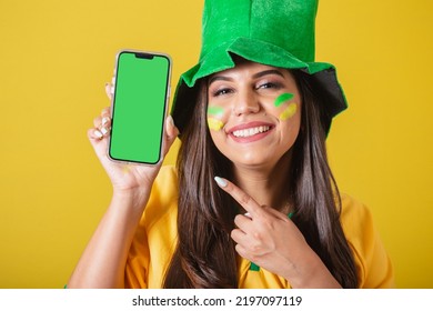 Woman Supporter Of Brazil, Holding Cell Phone, Showing Device Screen With Finger, For Application And Technology Ads. Promotions.