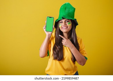 Woman Supporter Of Brazil, Holding Cell Phone, Showing Device Screen With Finger, For Application And Technology Ads. Promotions.