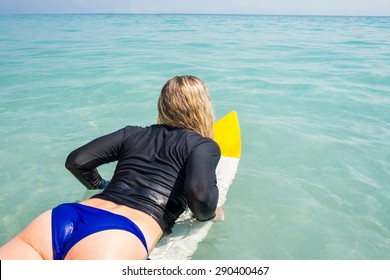 Woman with a surfboard on a sunny day at the beach