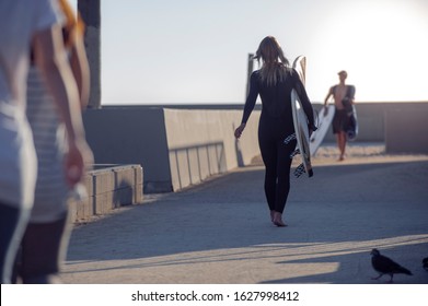 Woman Surfer On A Beach, Holding A Surf Board. Sun Set. Venice Beach, California