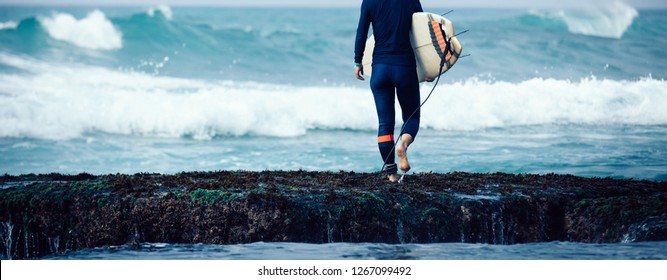 Woman surfer with surfboard going to surf - Powered by Shutterstock