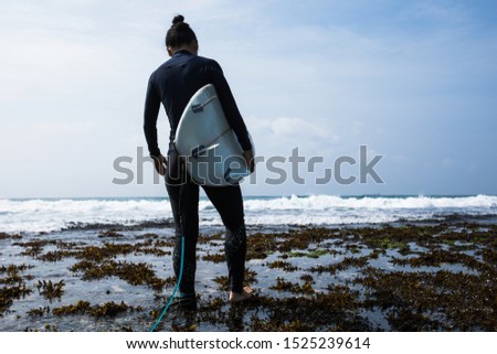 Woman surfer with surfboard going to surf