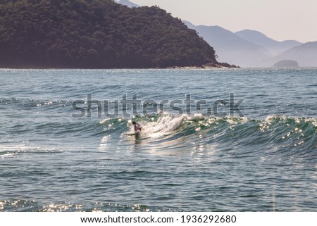 Woman surfing in Brazilian beach at sunrise