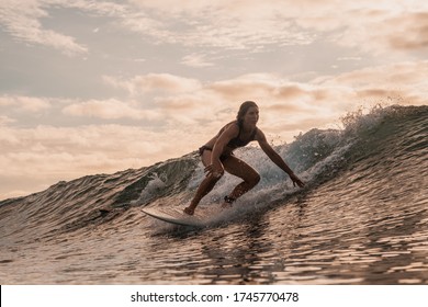 A Woman Surfing In The Mentawai Islands, Sumatra, Indonesia