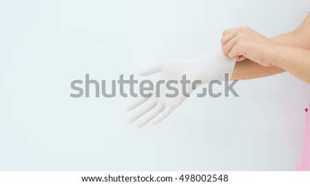 woman surgeon doctor wear glove before operation, Medical gloves,Doctor or nurse  putting on protective gloves, on light ,protective gloves isolated on white background