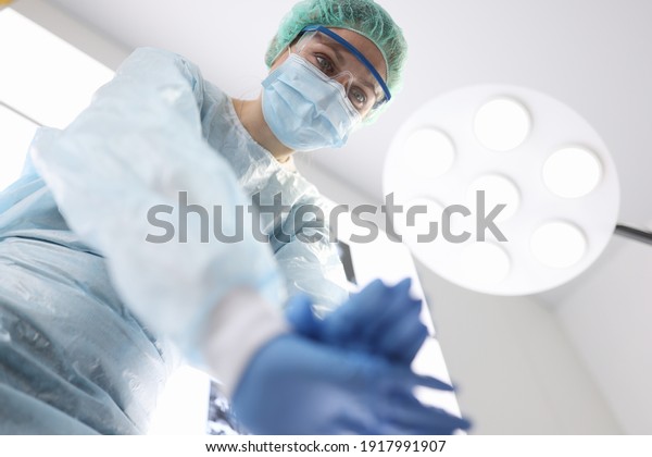 Woman surgeon doing heart\
massage to patient in operating room. Resuscitation aid\
concept