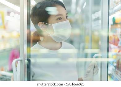 Woman With The Surgical Mask And Gloves, Looking For The Drinks, In Beverage Cooler In Grocery Shop After Coronavirus Pandemic.Shot Through Glass