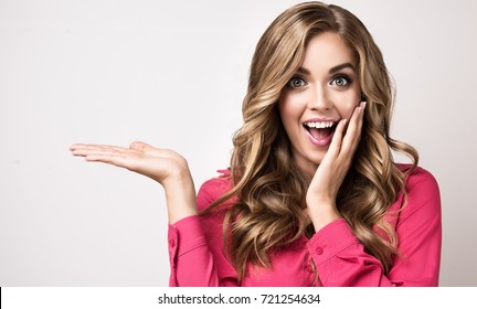 Woman surprise showing product .Beautiful girl  pointing to the side . Presenting your product. Expressive facial expressions emotions  businesswoman
,
