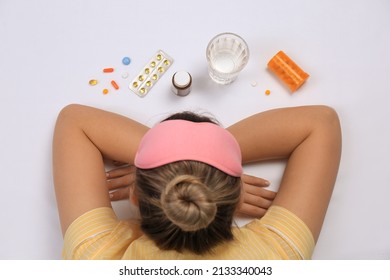 Woman Surrounded By Different Pills On White Background, Top View. Insomnia Treatment