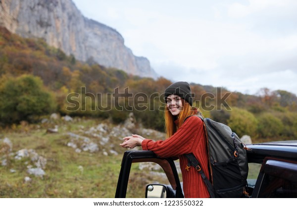 woman in a sweater and a\
backpack on the back machine nature tourism                        \
     