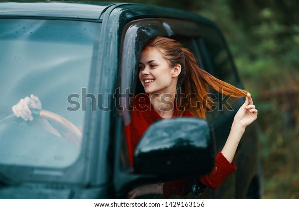 woman\
in a sweater driving a car, cropped view of\
nature