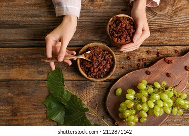 Woman with sweet raisins in bowls at table - Shutterstock ID 2112871142
