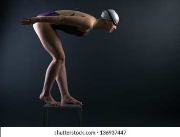 Woman swimmer prepared to jump into the water. - Powered by Shutterstock