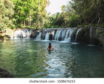 Woman Swimming Alone At The Tropical Wild Nature Of Waterfalls, Cambugahay Falls In Siquijor Island In Philippines