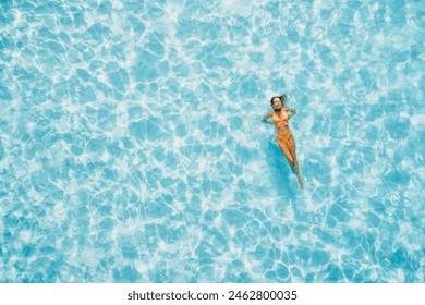 Woman swimming and chilling in transparent blue sea. Drone view, top down view. - Powered by Shutterstock