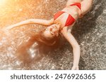 Woman swimming floating in calm sea. Happy smiling woman with long hair and fit body enjoys sea beach during summer vacation holidays. Concept of body image and fitness, enjoying a serene beach.