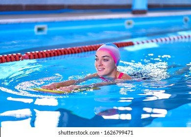 Woman In Swimming Hat Learns To Swim In Sports Pool In Leisure Center