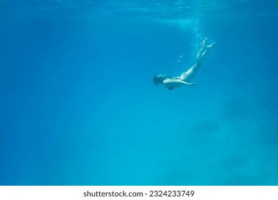 Woman swimming in open sea. Close up underwater photo. Diving girl in open water. High quality photo - Powered by Shutterstock