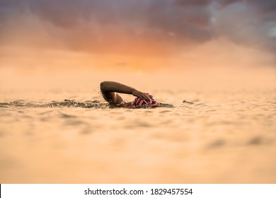 Woman swimming in open water at a beautiful sunrise - Powered by Shutterstock