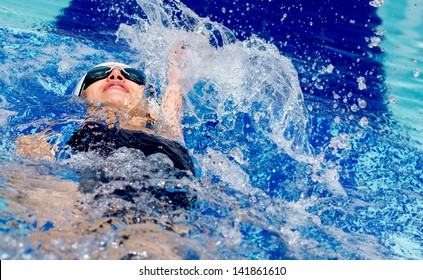 Woman Swimming At The Pool On Her Back