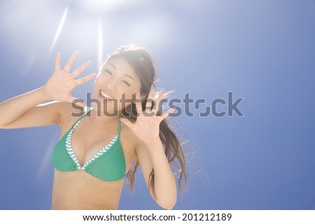 The woman with a swimming suit waving under the sun