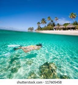 Woman Swimming In A Tropical Lagoon In Front Of Exotic Island