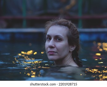 A Woman Swims In A Mineral Spring Outdoors. Evening Swim In The Mineral Pool