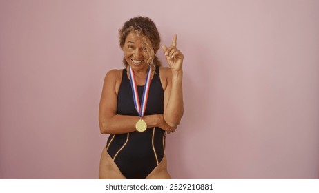 Woman in swimsuit with gold medal smiling against pink background showing pride and achievement - Powered by Shutterstock