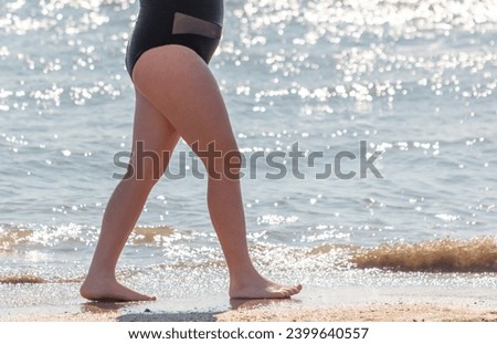 A woman in a swimsuit swims in the sea.