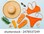 Woman swimwear and beach accessories flat lay top view. Top view with bikini outfit on color background. Vacation concept copy space.