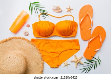 Woman swimwear and beach accessories flat lay top view on colored background Summer travel concept. bikini swimsuit, straw hat and seasheels. Copy space Top view. - Shutterstock ID 2152065425