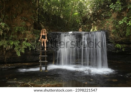 woman in swimwear at waterfall surrounded by forest, in the Amazon region, in Serra do Divisor National Park, in the state of Acre Foto stock © 