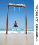 A woman swings on a swing on the seashore. Al Khan beach. UAE,Sharjah