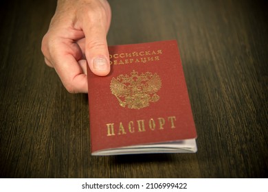 The woman at the table gives the Russian passport for verification. Inscription in Russian: Passport of Russia. - Shutterstock ID 2106999422