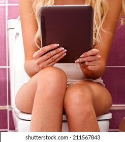 Woman with a tablet pc in a toilet