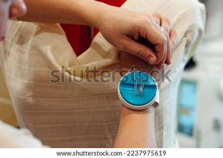 Woman tailor trying dress on mannequin in a home workshop,hands close-up.Small business.Selective focus.