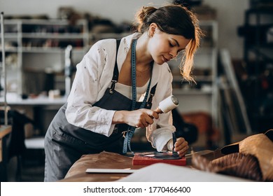 Woman tailor working on leather fabric - Powered by Shutterstock