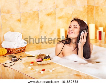 Woman take bath and listening to music .