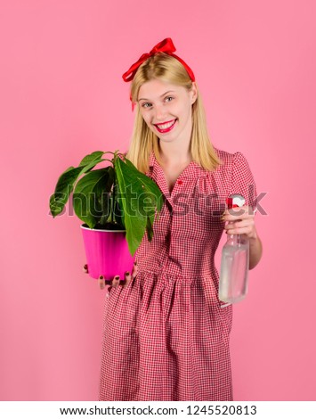Woman take care of flowers. Girl cultivating flowers. Woman with spray bottle spraying houseplants. Watering concept. Housewife spraying plant with water. Woman with sprayer flowers in pot. Irrigation