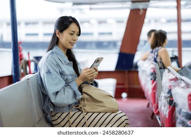 Woman take ferry with her mobile phone in Hong Kong city - Powered by Shutterstock