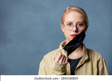 Woman Is Take Off A Black Face Mask On Grey Background 