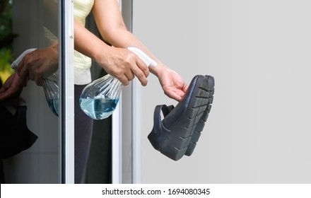 Woman Take Off Her Shoes And Clean With Alcohol Before Entering A House For Protect Infected From Covid-19