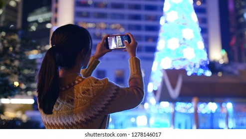 Woman take photo on christmas tree decoration