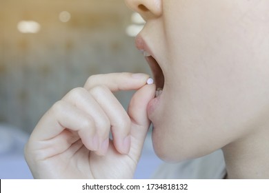 A Woman Take A Pill Under Tongue For Heart Disease 